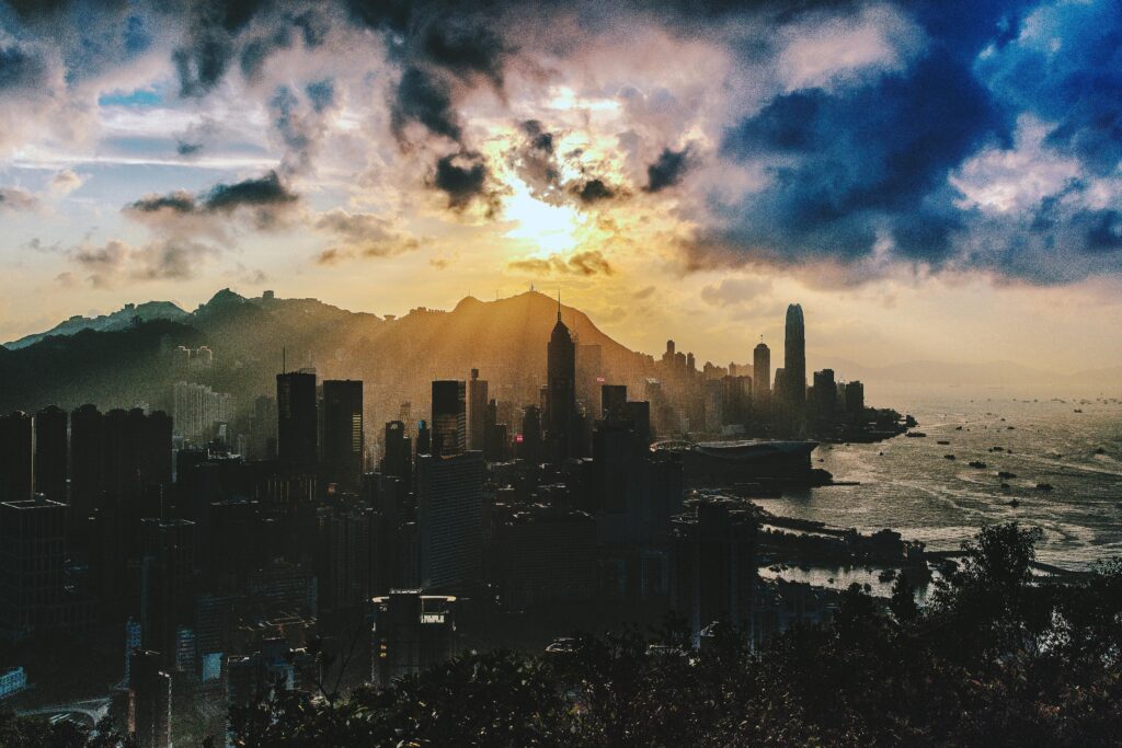 Dramatic sunset over the skyline of Hong Kong Island with vibrant colors and sea view.